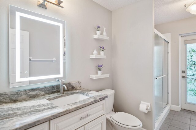 bathroom with toilet, a stall shower, vanity, and tile patterned flooring