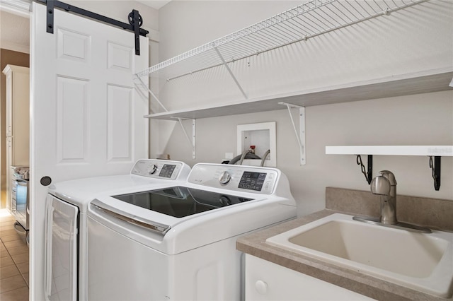 washroom featuring a barn door, light tile patterned floors, laundry area, independent washer and dryer, and a sink