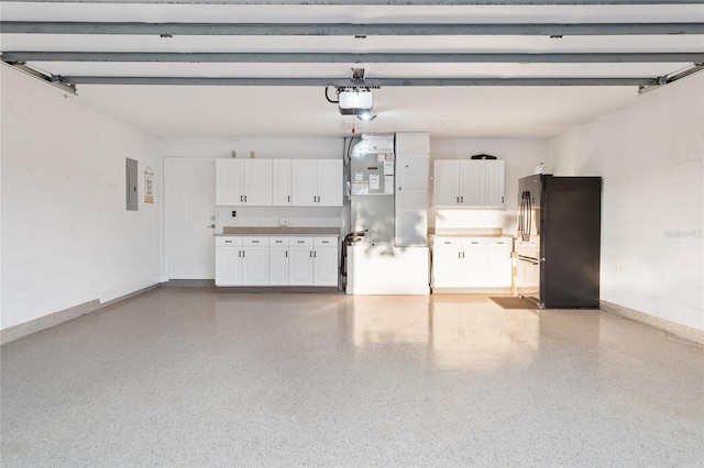 garage featuring electric panel, baseboards, a garage door opener, and freestanding refrigerator