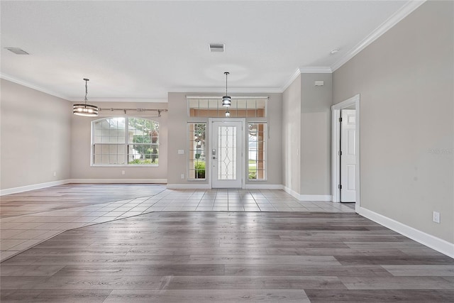 foyer entrance featuring visible vents, wood finished floors, and crown molding