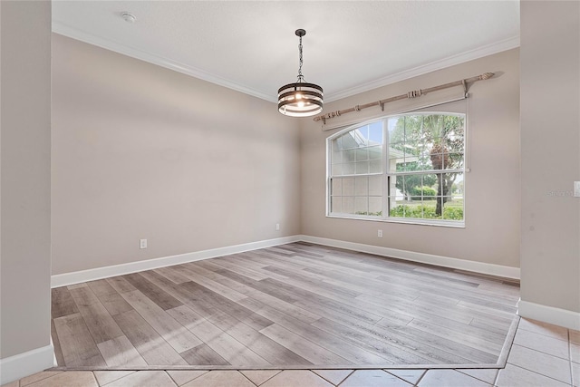 empty room featuring baseboards, light wood-style floors, and ornamental molding