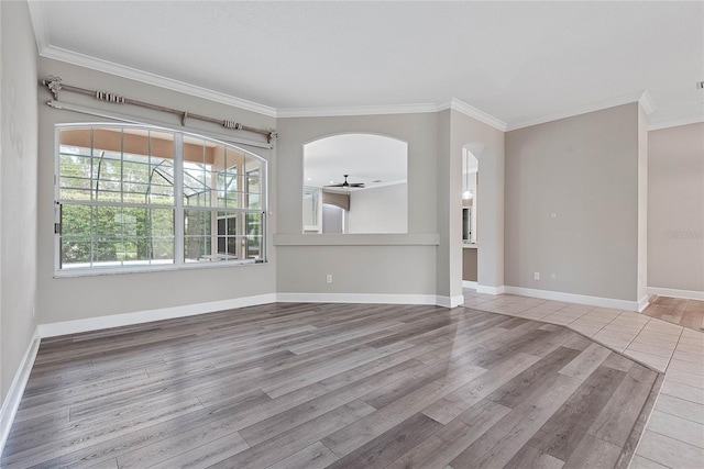 unfurnished living room featuring ceiling fan, wood finished floors, baseboards, and ornamental molding