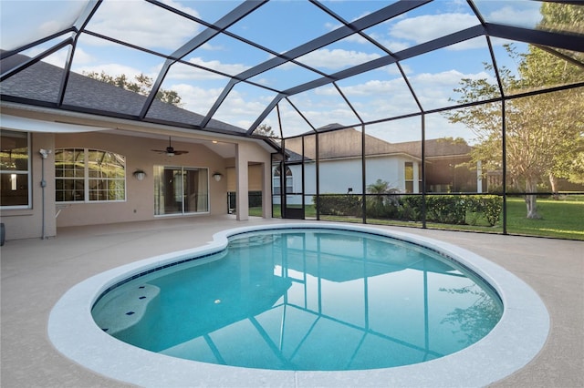 pool featuring glass enclosure, a patio, and ceiling fan