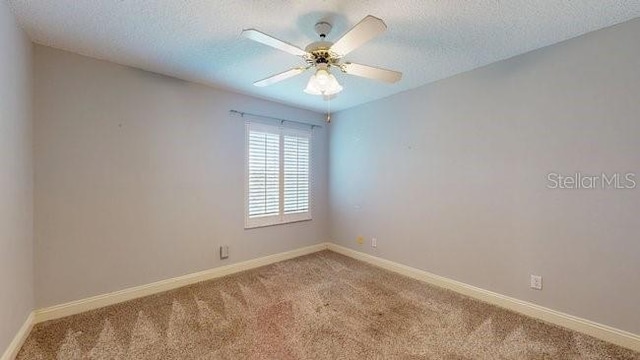 carpeted empty room featuring a ceiling fan, baseboards, and a textured ceiling