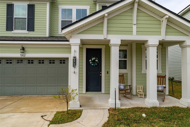 562 Kendall Crossing Dr, Saint Johns, FL 32259 - doorway to property featuring an attached garage, a shingled roof, covered porch, and driveway