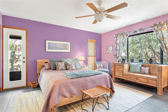 tiled bedroom with multiple windows, a textured ceiling, and a ceiling fan