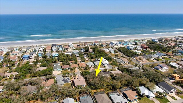 drone / aerial view featuring a view of the beach, a residential view, and a water view