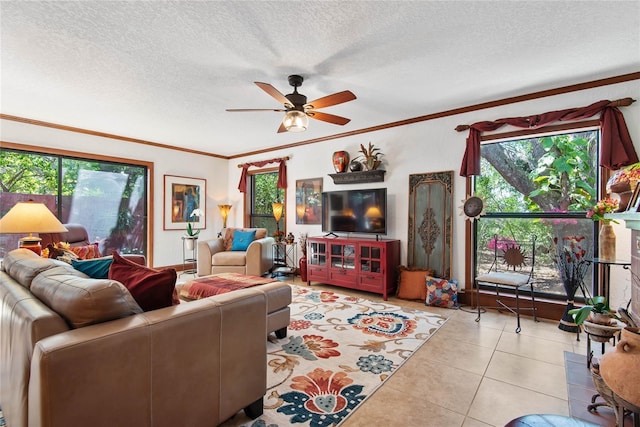 living area with a textured ceiling, a ceiling fan, crown molding, and tile patterned flooring