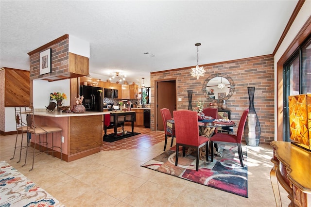 dining space with light tile patterned floors, a textured ceiling, and brick wall