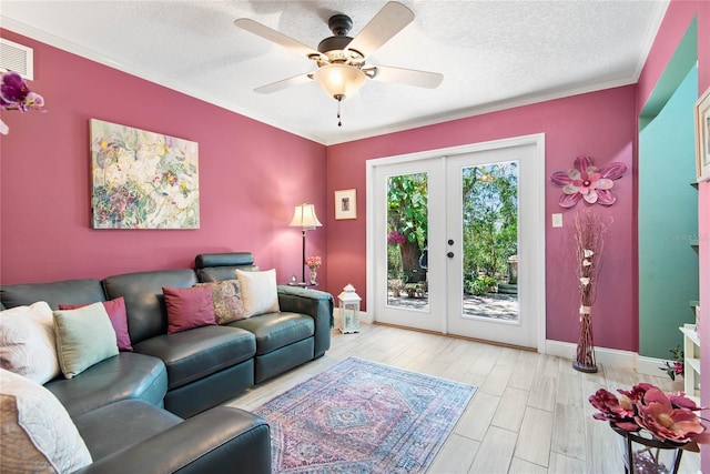 living room with a ceiling fan, visible vents, light wood-style flooring, french doors, and a textured ceiling
