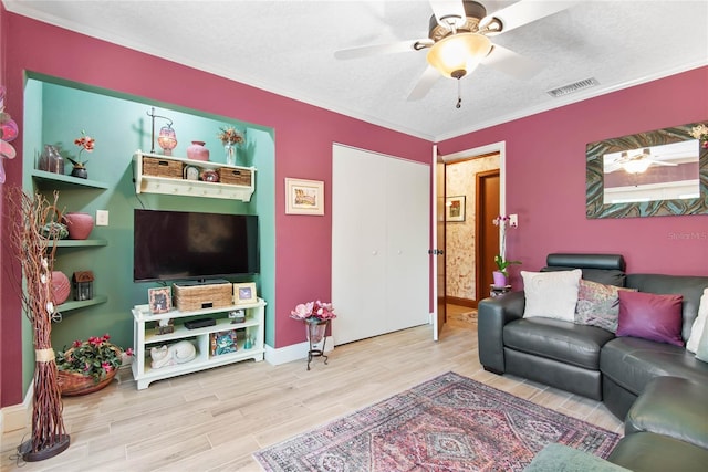 living room with visible vents, ornamental molding, wood finished floors, a textured ceiling, and a ceiling fan