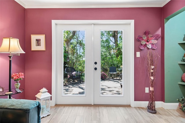 doorway to outside featuring french doors, crown molding, baseboards, and wood finished floors