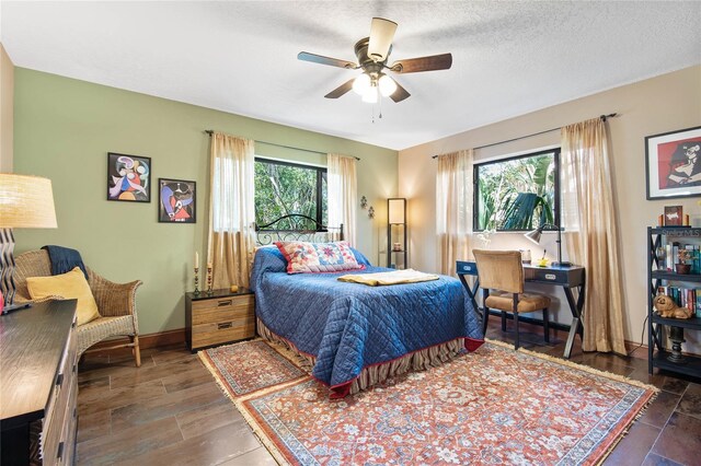 bedroom featuring ceiling fan, a textured ceiling, and baseboards