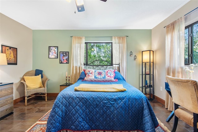 bedroom with baseboards, multiple windows, and a ceiling fan