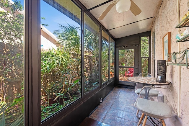sunroom with ceiling fan and lofted ceiling