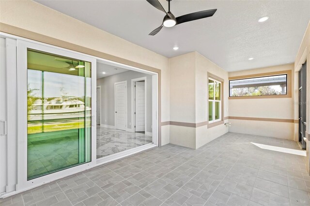 unfurnished sunroom with a ceiling fan