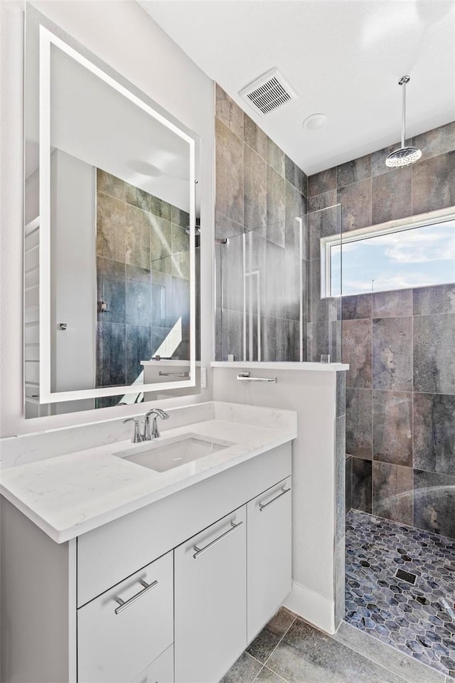 full bathroom featuring visible vents, walk in shower, and vanity