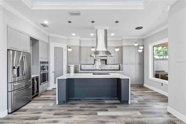 kitchen with island exhaust hood, stainless steel appliances, light countertops, visible vents, and modern cabinets