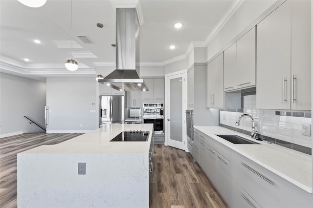 kitchen featuring island exhaust hood, stainless steel appliances, visible vents, ornamental molding, and a sink