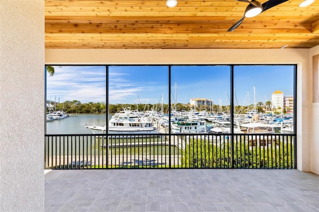 unfurnished sunroom with wooden ceiling and a water view