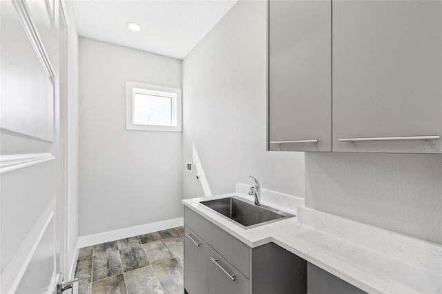 laundry area with cabinet space, baseboards, hookup for an electric dryer, a sink, and recessed lighting