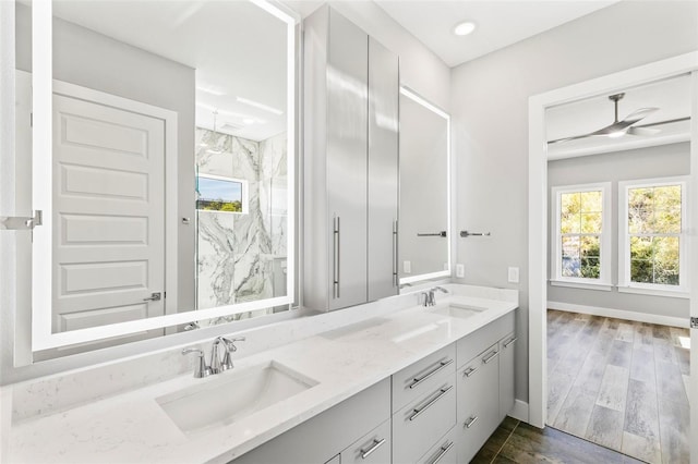 bathroom with plenty of natural light, a sink, and a marble finish shower