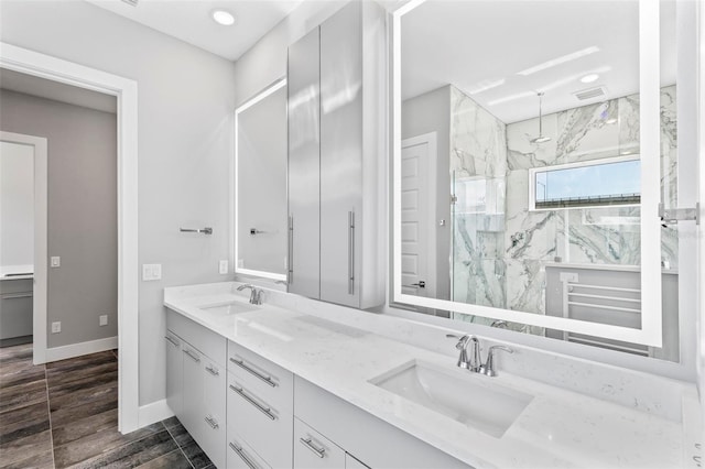 full bath with baseboards, visible vents, a sink, and a marble finish shower