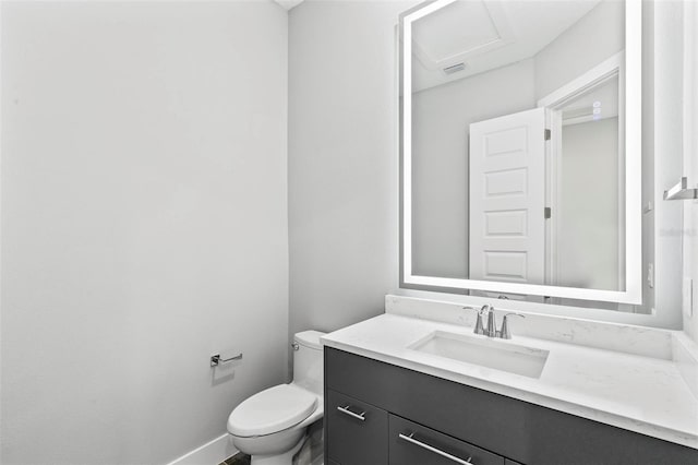 half bath with visible vents, vanity, toilet, and baseboards