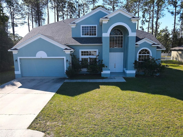 traditional home with stucco siding, driveway, a front lawn, a shingled roof, and a garage