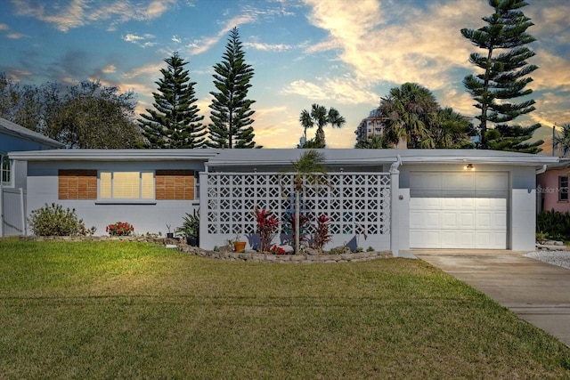 view of front facade featuring an attached garage, a front lawn, and concrete driveway