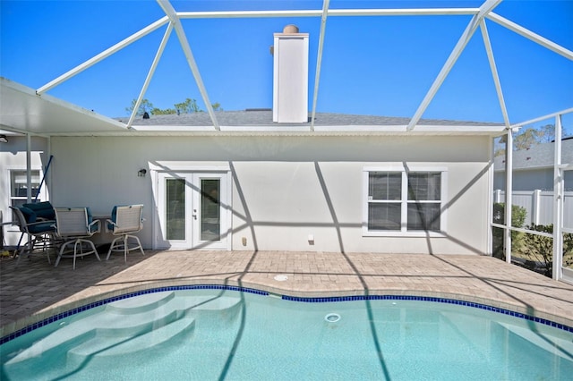 pool featuring glass enclosure, french doors, and a patio area