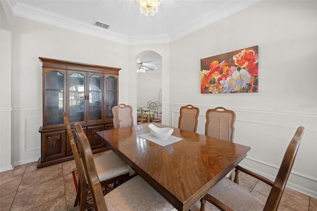 dining room with visible vents, arched walkways, a wainscoted wall, ornamental molding, and a decorative wall