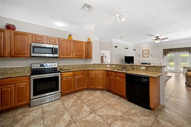 kitchen with stainless steel appliances, a sink, visible vents, open floor plan, and brown cabinetry