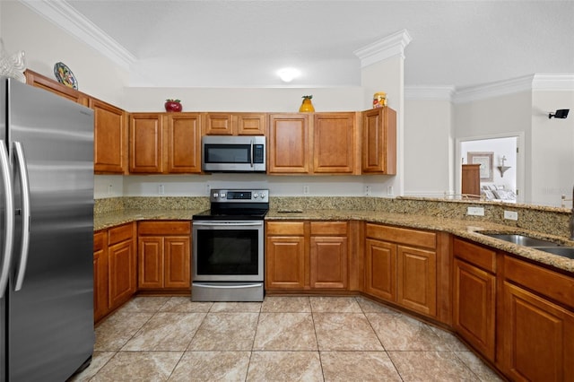 kitchen featuring stainless steel appliances, brown cabinetry, a sink, and ornamental molding