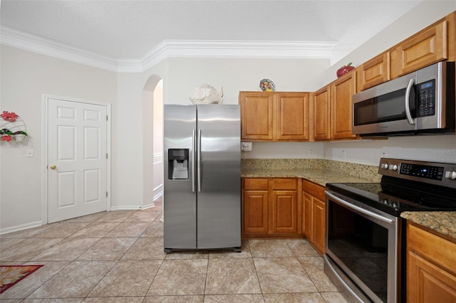 kitchen featuring appliances with stainless steel finishes, brown cabinets, and crown molding