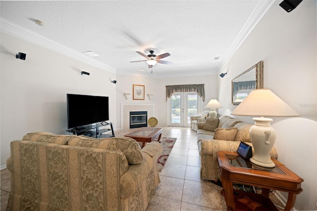 living room featuring french doors, crown molding, light tile patterned flooring, ceiling fan, and a textured ceiling