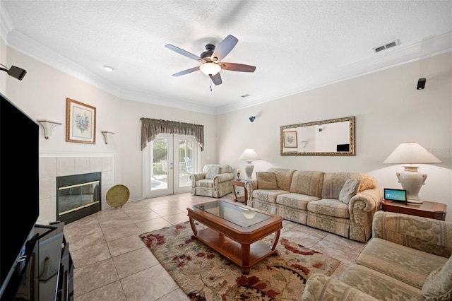 living room featuring light tile patterned floors, visible vents, french doors, a textured ceiling, and crown molding