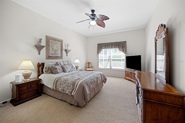 bedroom with a ceiling fan and light carpet