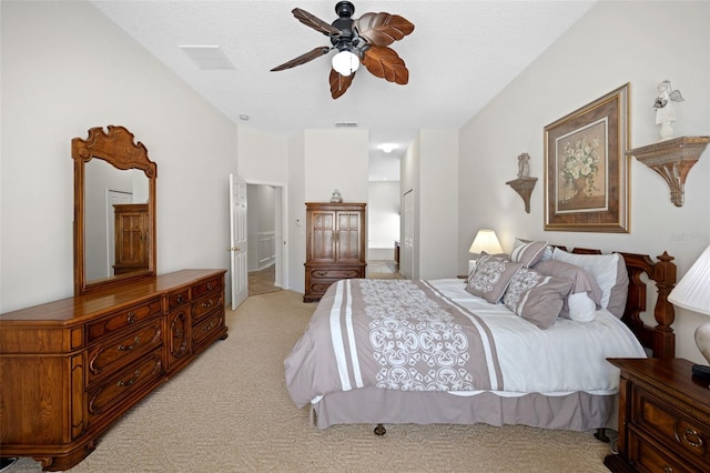 bedroom with a ceiling fan, light colored carpet, visible vents, and ensuite bathroom