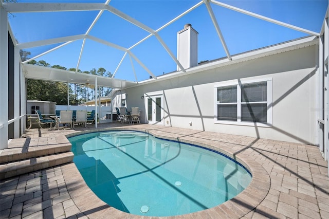 view of pool with outdoor dining area, glass enclosure, a patio, and french doors