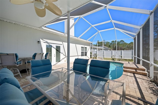 view of patio with a lanai, fence, a ceiling fan, a pool, and french doors