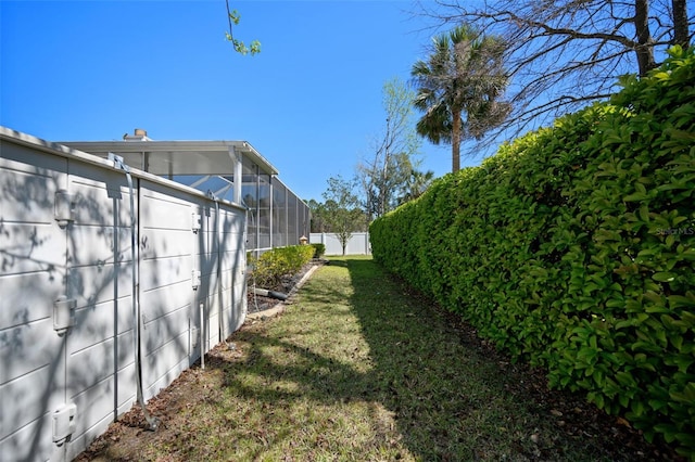 view of yard with a fenced backyard and a lanai