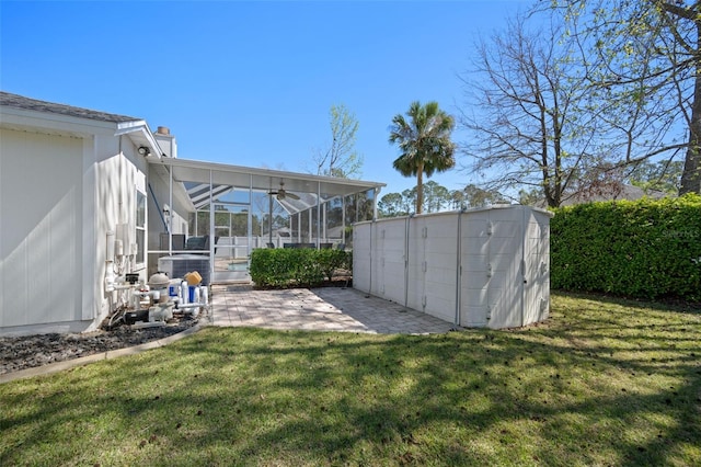 view of yard with an outbuilding, a storage unit, a patio area, and a ceiling fan