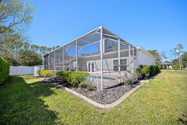 rear view of house with glass enclosure, fence, a fenced in pool, and a yard