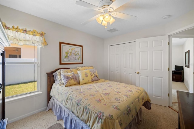 bedroom with ceiling fan, visible vents, a closet, and light colored carpet