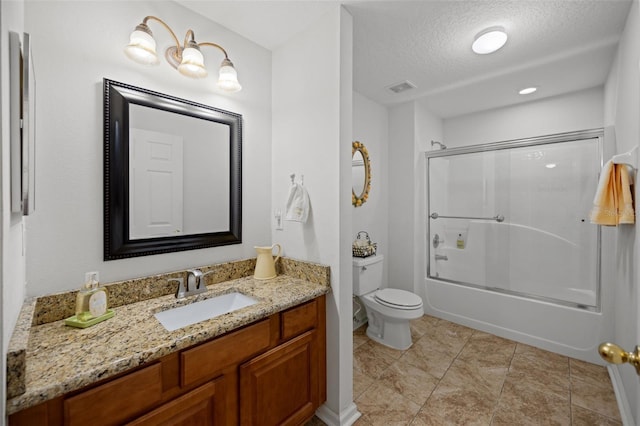 bathroom featuring bath / shower combo with glass door, visible vents, toilet, vanity, and a textured ceiling