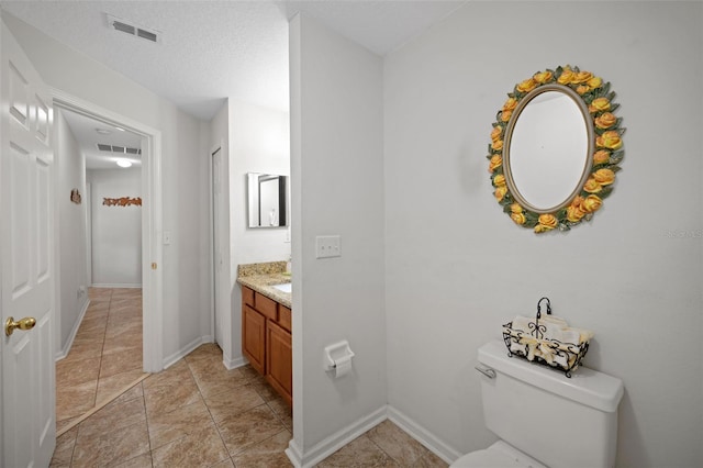 bathroom with baseboards, visible vents, vanity, and toilet