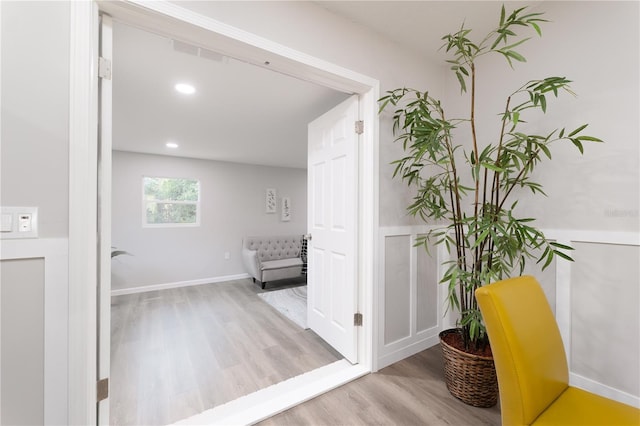 hallway featuring baseboards, wood finished floors, and recessed lighting