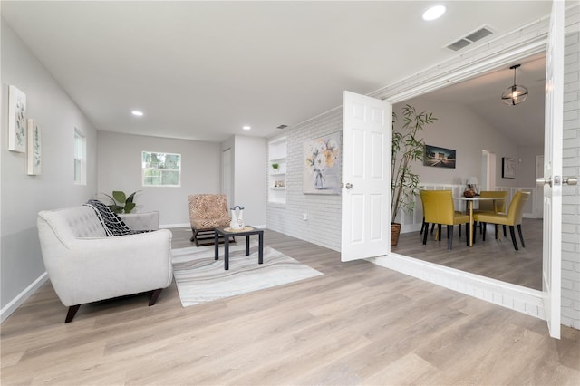 living area with baseboards, wood finished floors, visible vents, and recessed lighting