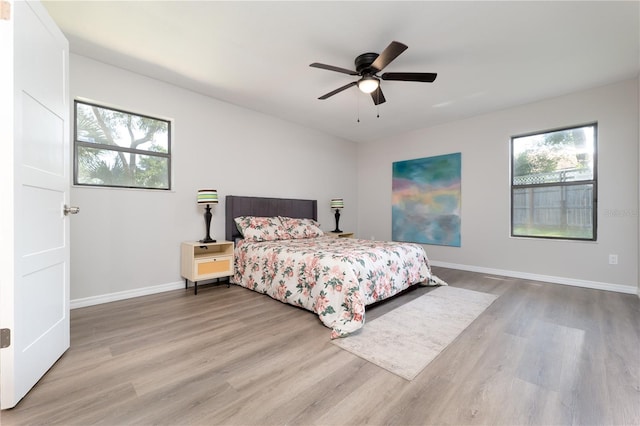 bedroom with wood finished floors, a ceiling fan, and baseboards